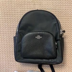 Used Coach backpack. Black. Nylon with leather trim. Light scratches on nylon.